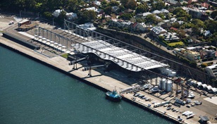 Bounded by land on it's northern and western sides, and water to the south and east, the 240m long and 50m wide gantry sits atop a vast concrete iced apron that is mostly reclaimed land.